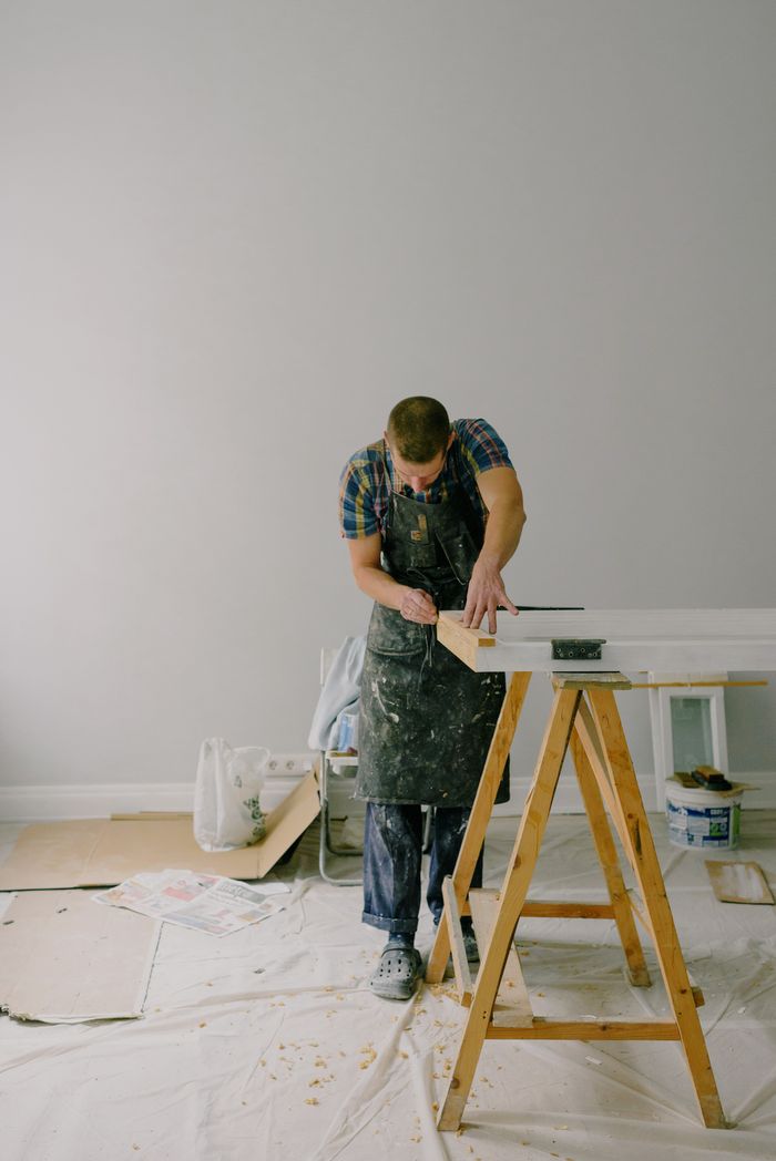 The Art of Drawing Readers In: Your attractive post title goes here Full length of skilled craftsman in dirty apron repairing and restoration wooden window in light room